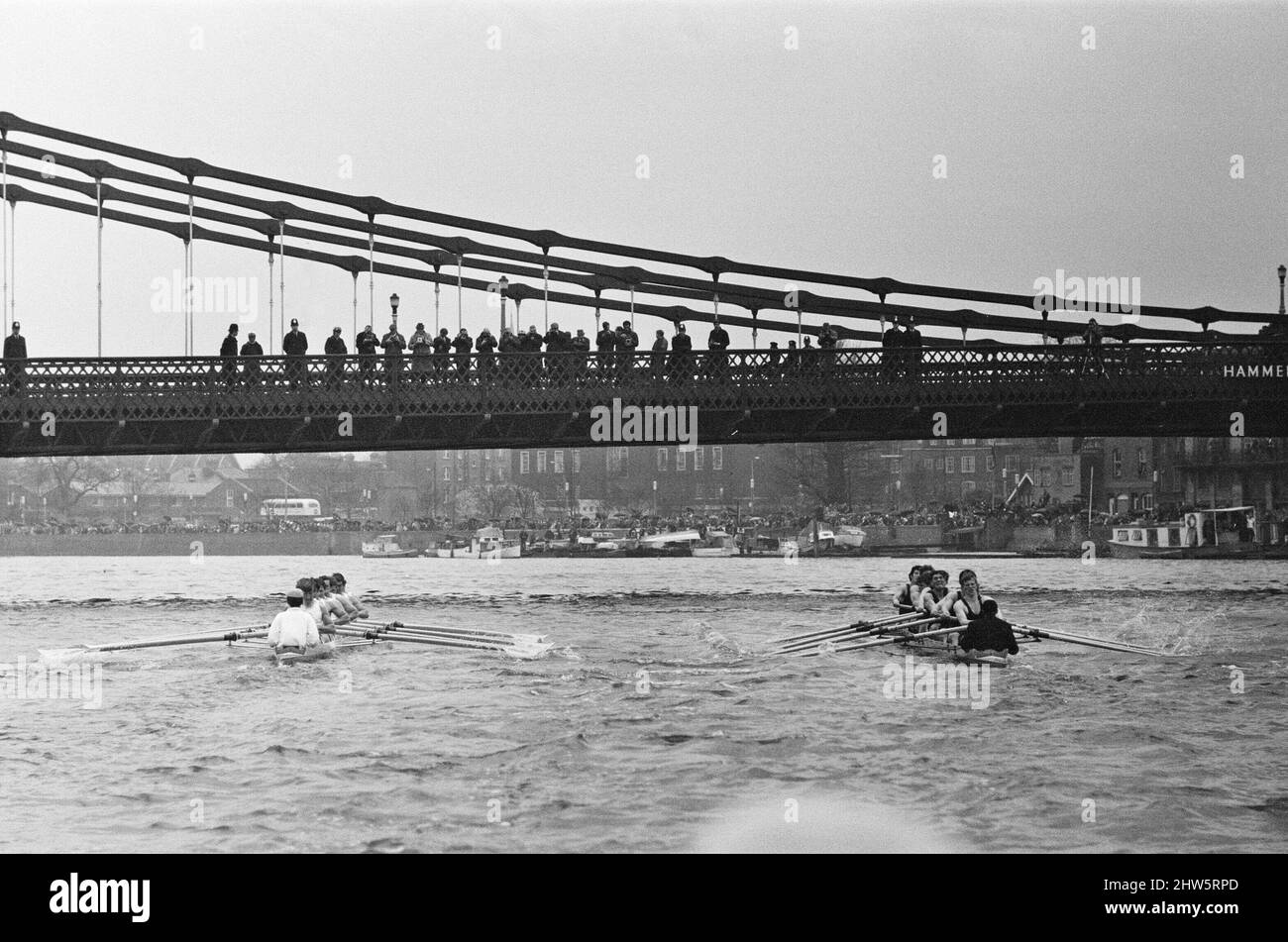 The Oxford Versus Cambridge Boat Race, en el río Támesis, marzo de 1968. La imagen muestra los canoas que pasan por debajo del puente Hammersmith. La Boat Race 114th tuvo lugar el 30 de marzo de 1968. El evento, que se celebra anualmente, es una carrera de remo en paralelo entre equipos de las universidades de Oxford y Cambridge a lo largo del río Támesis. La carrera, despiñada por Harold Rickett, fue ganada por Cambridge en tres longitudes y media. Goldie ganó la carrera de reserva y Cambridge ganó la carrera de botes femeninos. La carrera se llevó a cabo desde el punto de partida en Putney Bridge en el río Támesis en Londres, hasta la línea de meta en Chiswick Bri Foto de stock