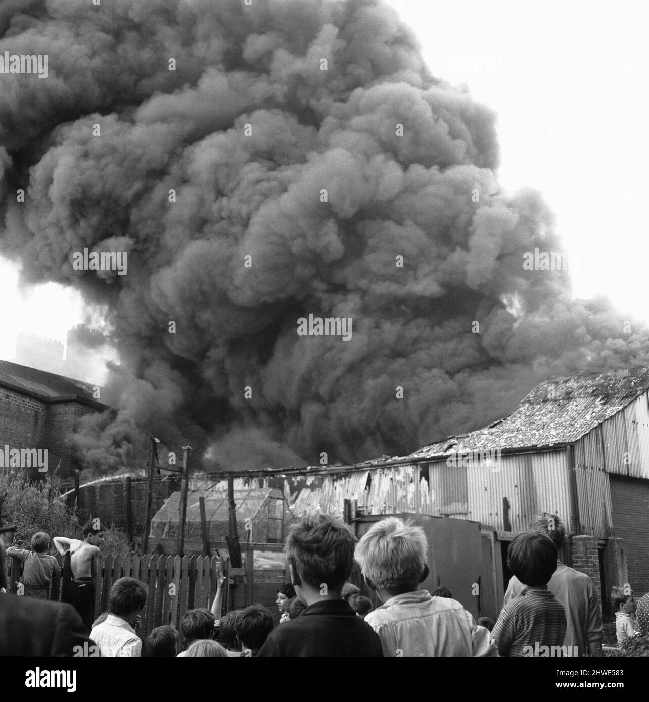 El fuego de almacén de neumáticos Firestone, Westgate Hill, Newcastle. 31st de julio de 1969Families, la vida cercana tuvo que ser evacuada cuando todo el complejo de edificios se incendió. En una etapa, 56 bomberos y 15 aparatos de bomberos estaban atacando el enorme incendio. El humo denso se estaba elevando al cielo de la noche y se podía ver tan lejos como South Shields y Ponteland. En la altura de las latas de pintura y grasa en un almacén estaban explotando y golpeando el techo enviando azulejos y bate 100ft en el aire, pero la gente todavía se atormentaba en la calle para ver lo que estaba sucediendo. Foto de stock