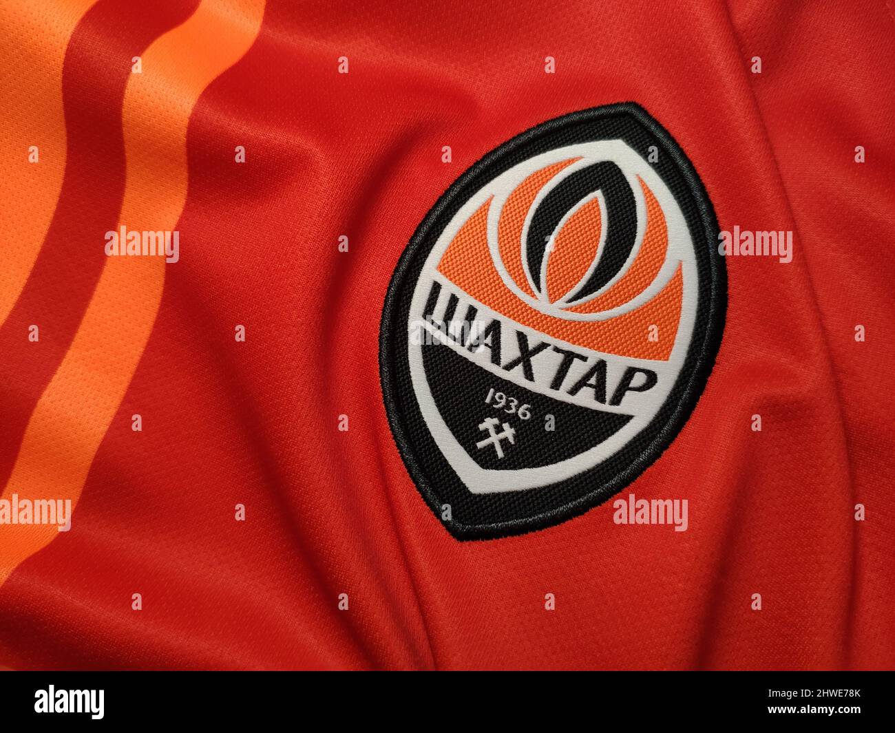Kiev, Ucrania - enero de 2022: Emblema del FC Shakhtar Donetsk sobre el fondo naranja de la camiseta de la casa Foto de stock