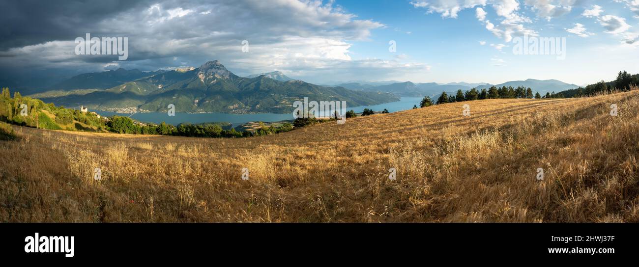 Serre-Poncon lago en verano con la tormenta que se aproxima. Vista panorámica de los pueblos de Saint-Apollinaire y Savines-le-Lac. Altos Alpes. Francia Foto de stock