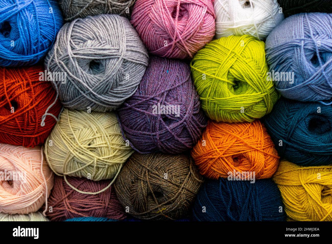 Muchos hilos de lana en colores brillantes apilados en el estante en la  tienda, bolas de lana multicolor para tejer ropa y accesorios caseros  calientes. Popular Fotografía de stock - Alamy