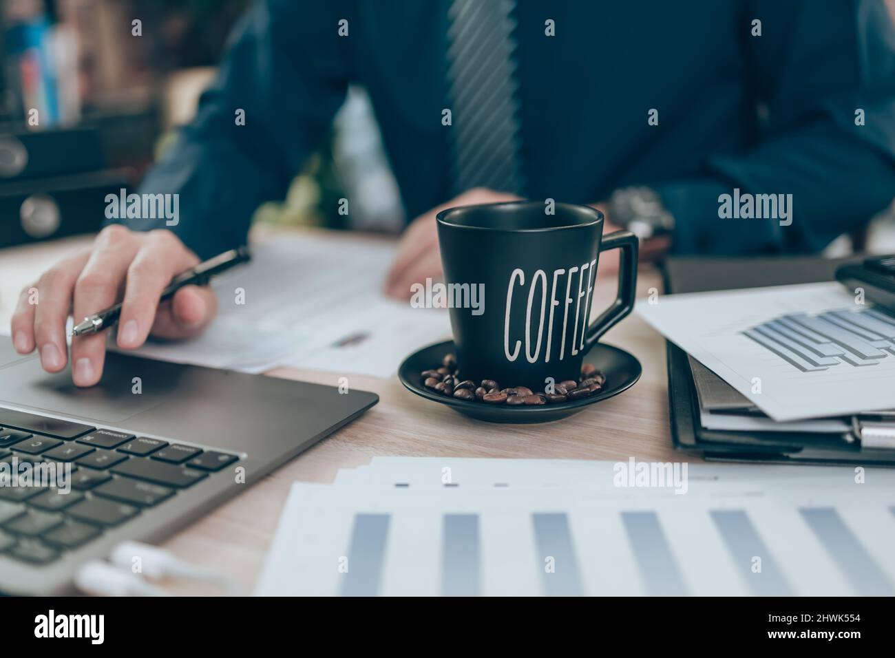 Taza de café en el escritorio de la oficina y contable trabajando en la