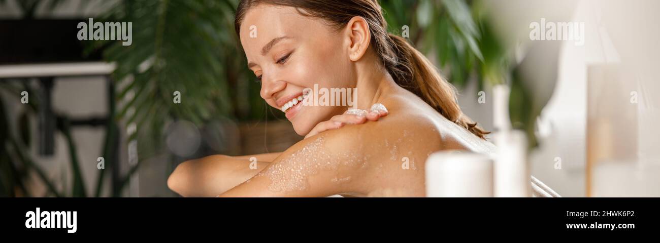 Retrato de una mujer joven sonriente bañándose y cuidando su cuerpo en el balneario Foto de stock
