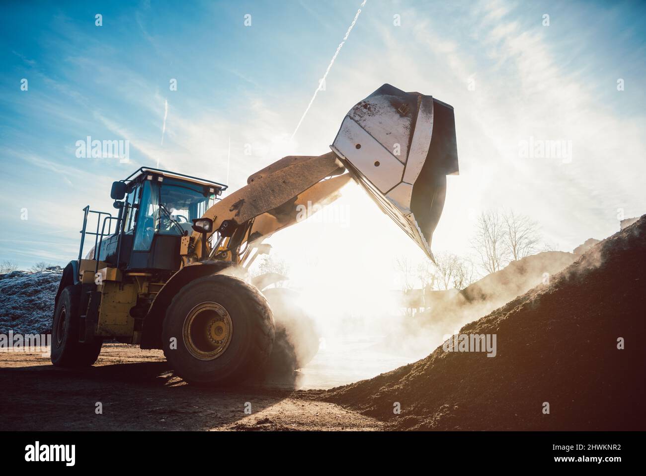 Bulldozer poniendo biomasa en pila para compostaje Foto de stock