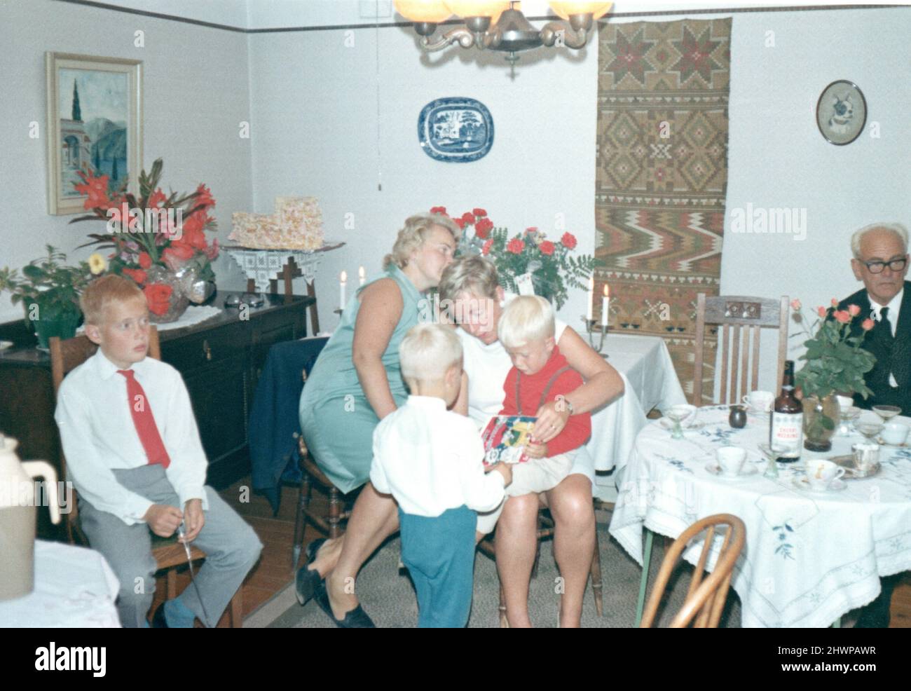 Fotografía original de los años 70 de la familia sueca elegantemente vestida en interiores, Suecia. Concepto de unión, antaño, nostalgia Foto de stock