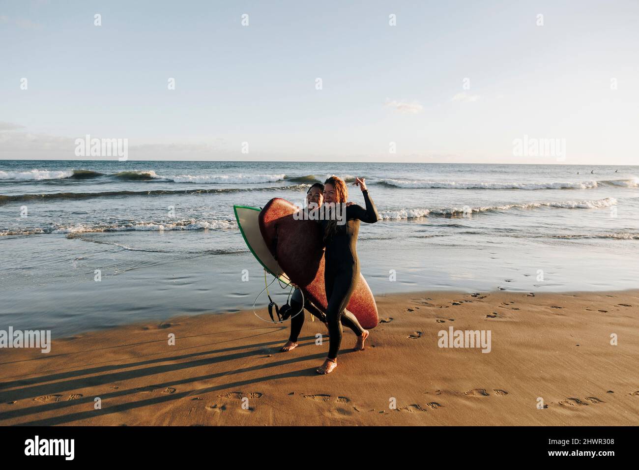 Alegres mujeres surfistas tablas de surf caminar arena playa