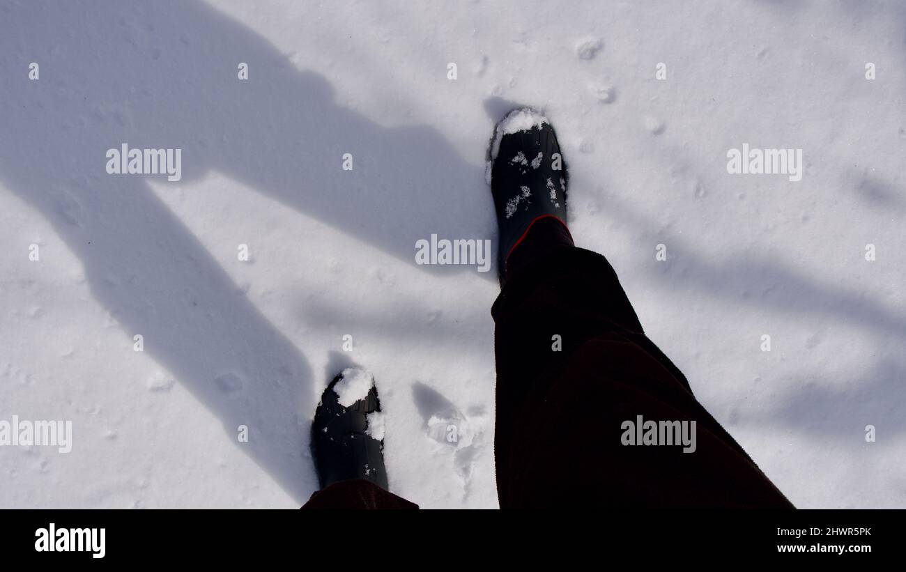 Hombre caminando en terreno nevado. Hombre caminando con botas en sus pies. Foto de stock