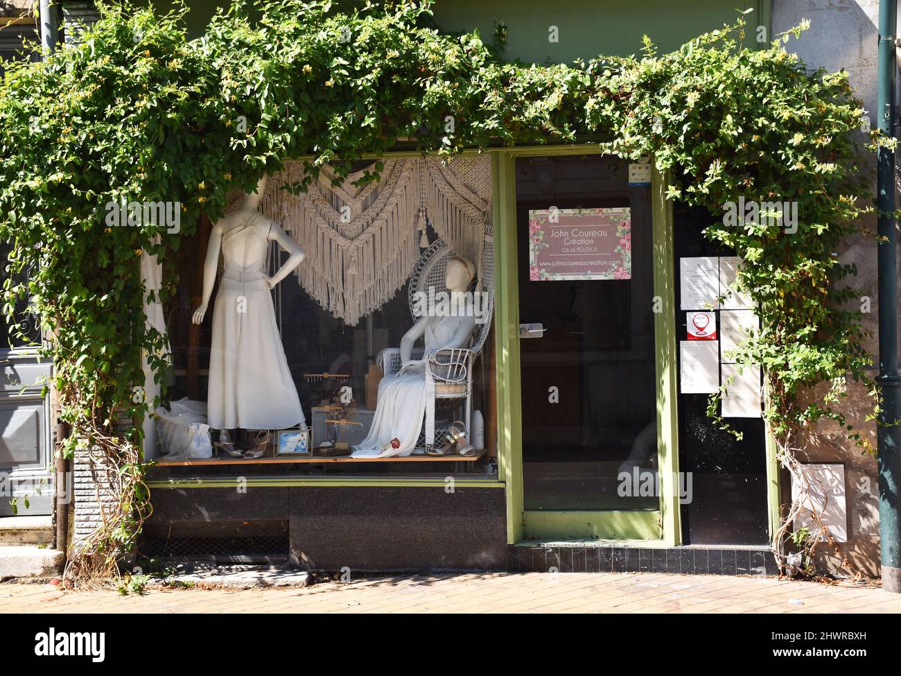 La hermosa ventana frontal de la tienda nupcial John Coureau Création en Burdeos, Francia, enmarcada en madreselva Foto de stock