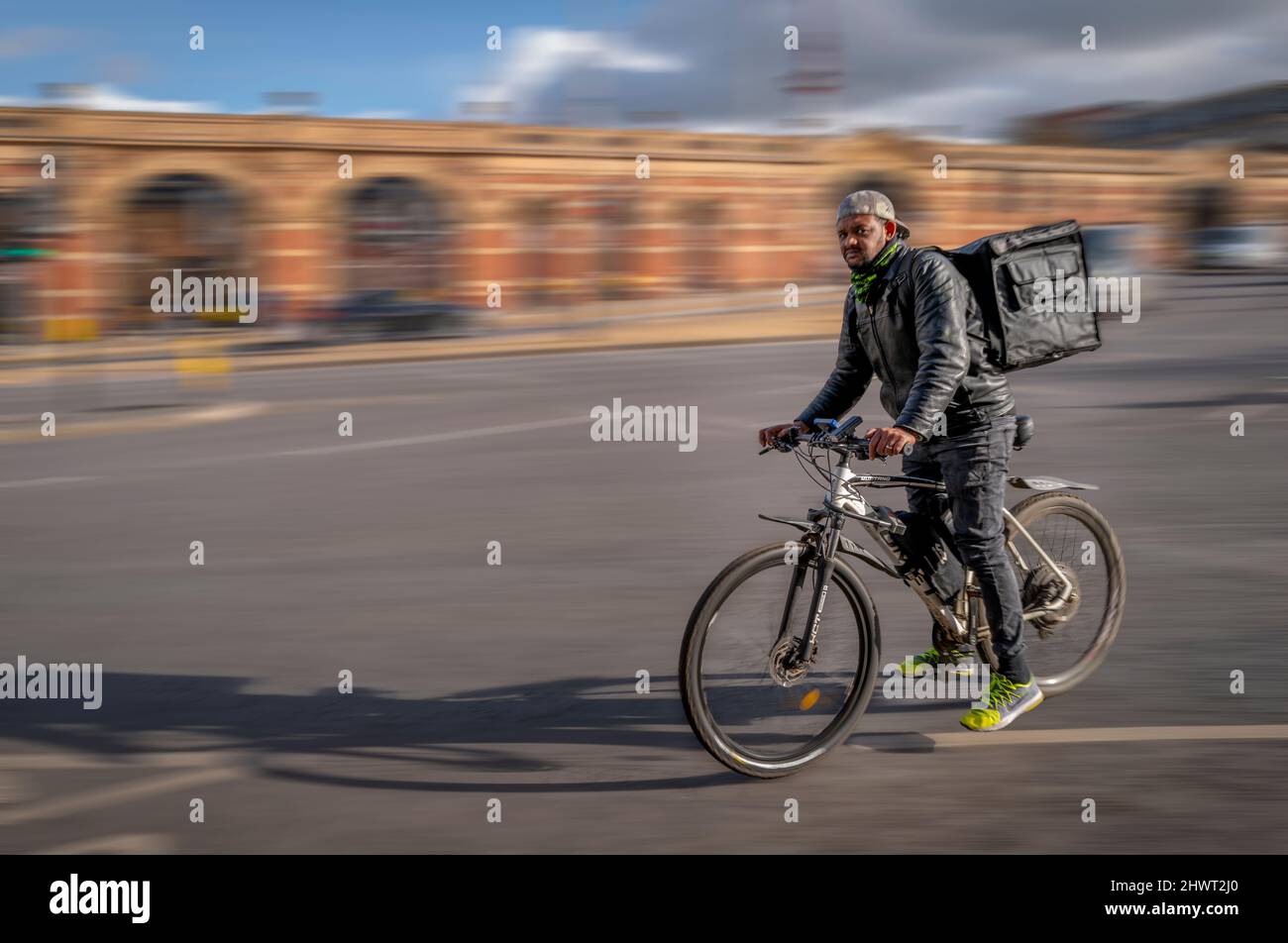 Un ciclista de entrega para llevar. Foto de stock