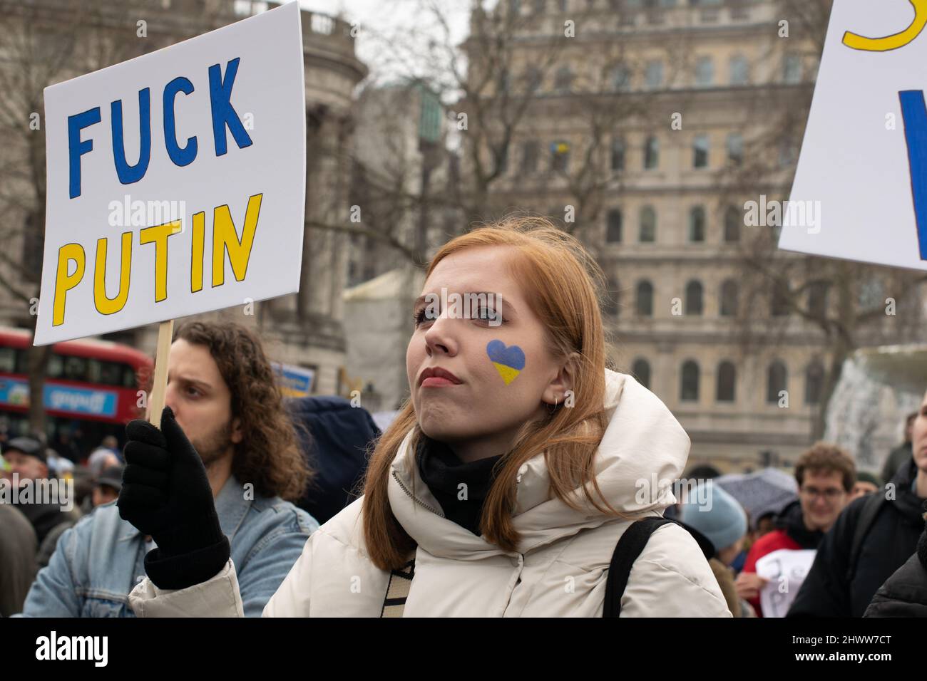 Protesta contra la invasión rusa de Ucrania, Trafalgar Square, Londres, Reino Unido. Protestor con corazón azul y amarillo en la cara sosteniendo un texto de signo Fuck Putin Foto de stock