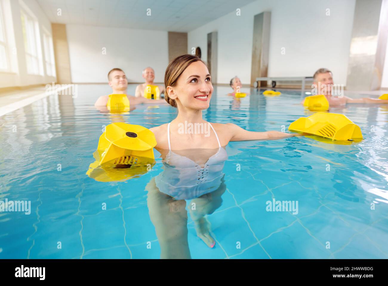 Mujer joven en clase de aeróbic acuático Foto de stock