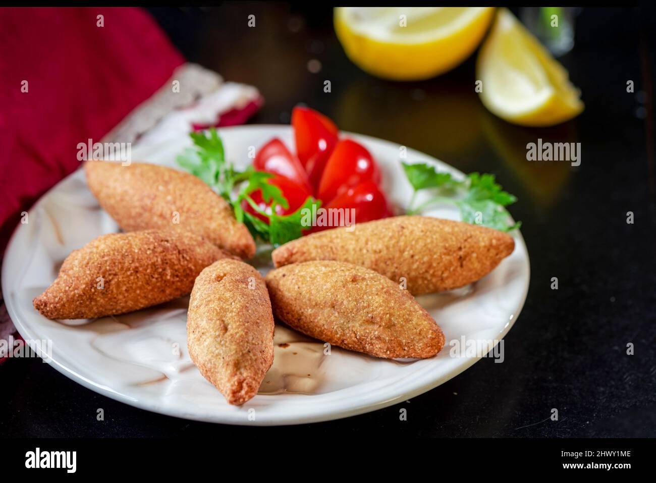 Tradicional comida frita preparada con bulgur y carne en un plato con ensaladas, primeros planos, fotografía de la vida fija Foto de stock