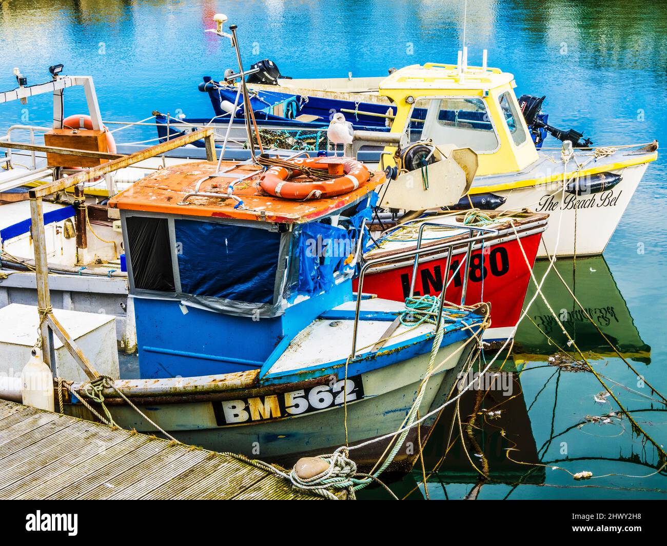 Coloridos barcos de pesca amarrados en el puerto de Brixham en Devon. Foto de stock