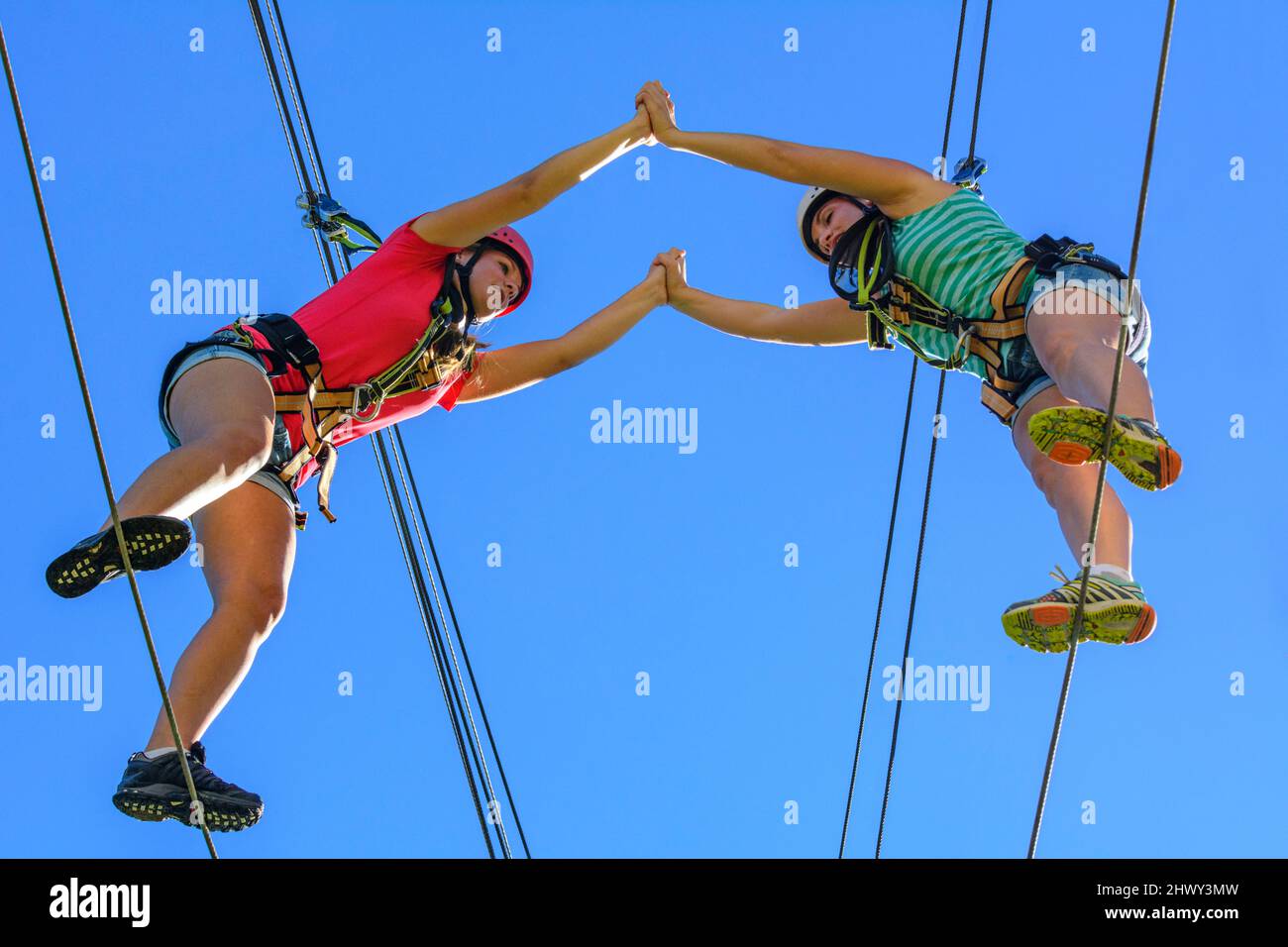 Dos mujeres jóvenes haciendo ejercicio de pareja en curso de cuerdas altas Foto de stock