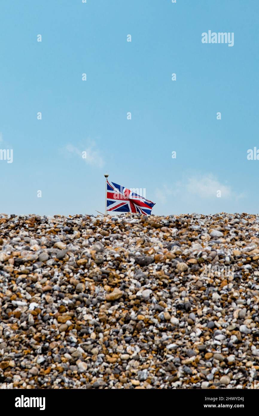 Bandera de British Union Jack volando sobre una playa de guijarros Foto de stock