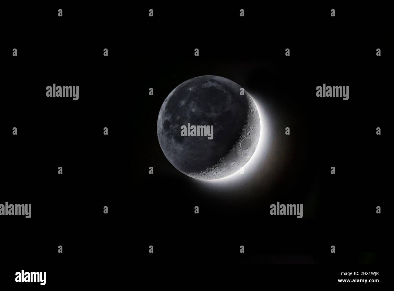 Media luna encerada y brillo de la tierra en el lado más oscuro de la Luna, Hemisferio Norte, Suiza Foto de stock
