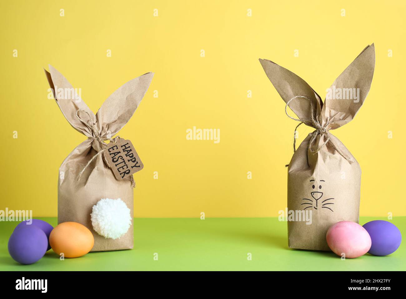 Bolsas de papel conejito con huevos de Pascua sobre fondo color Fotografía  de stock - Alamy