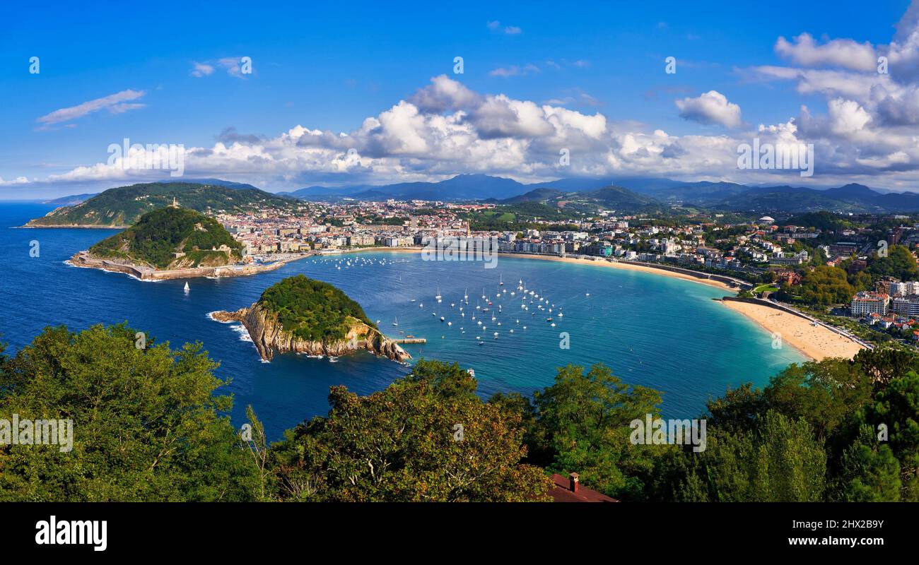 Vista de la Bahía de La Concha desde el Monte Igeldo, velero entre la Isla de Santa Clara y el Monte Urgull, Donostia, San Sebastián, ciudad cosmopolita de Foto de stock