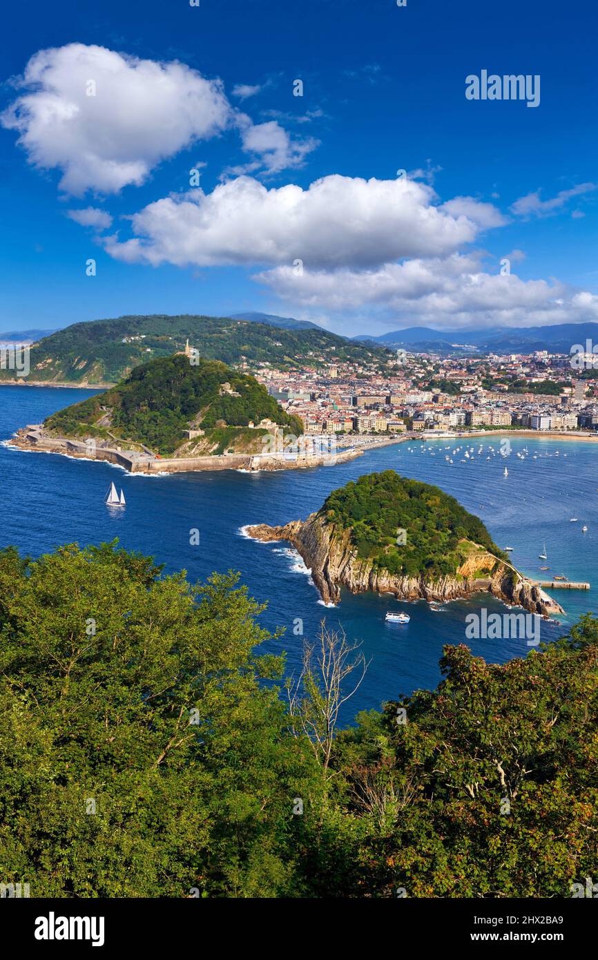 Vista de la Bahía de La Concha desde el Monte Igeldo, velero entre la Isla de Santa Clara y el Monte Urgull, Donostia, San Sebastián, ciudad cosmopolita de Foto de stock