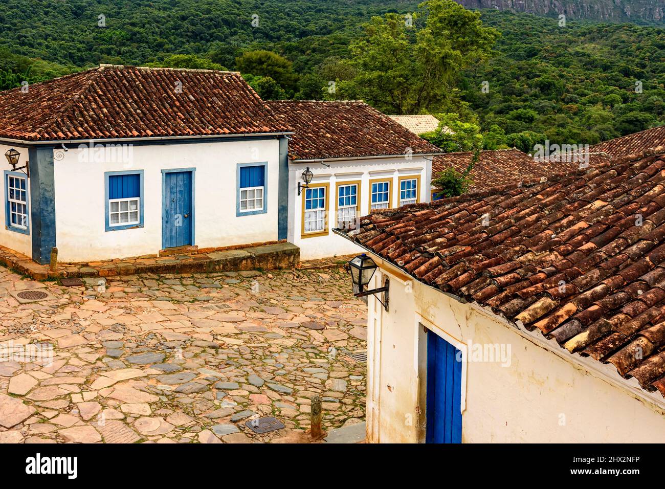 Calles y laderas con adoquines y antiguas casas de estilo colonial en la ciudad de Tiradentes, estado de Minas Gerais. Foto de stock