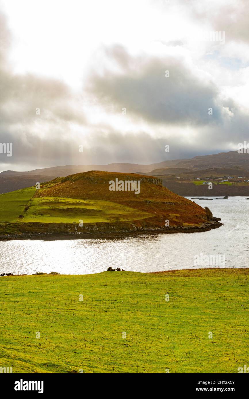 Rayos del sol a través de las nubes, paisaje con colores verde y naranja, Skye Island, Highlands, Escocia. Foto de stock
