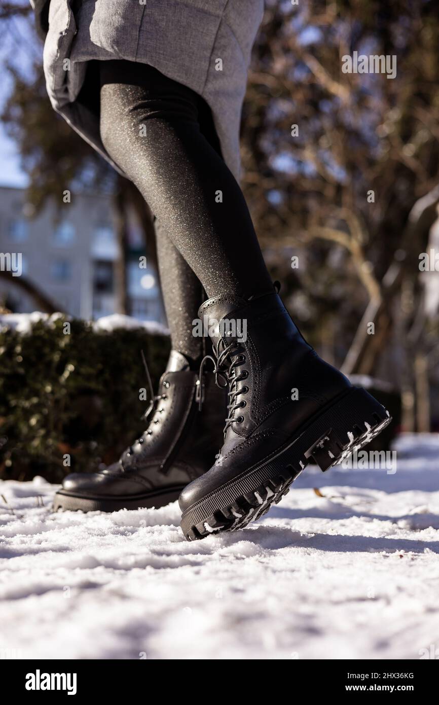 Mujer con botas negras de moda sobre nieve blanca, cerca. Piernas para mujer con elegantes de piel de invierno Fotografía de stock - Alamy
