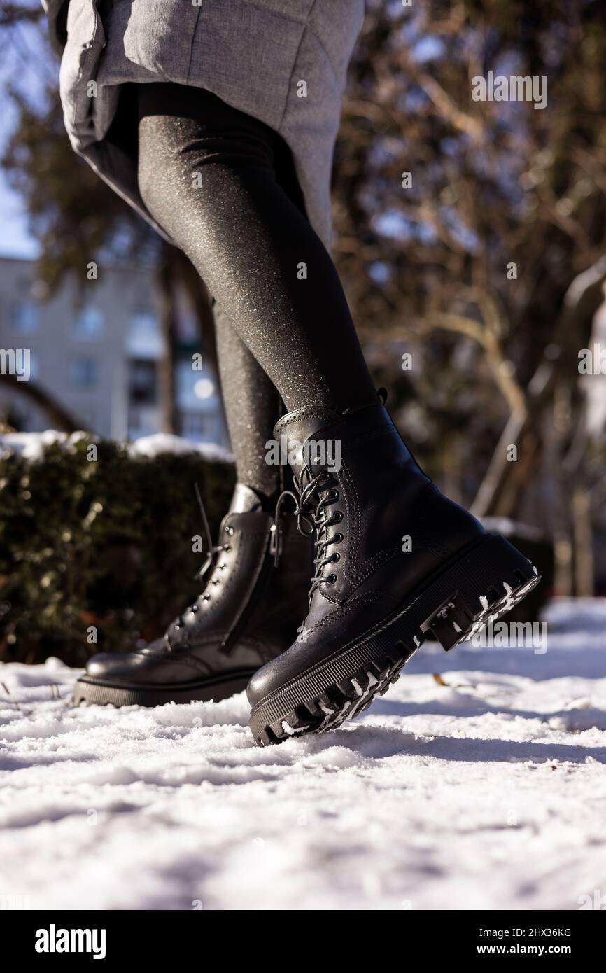 con negras de moda sobre nieve blanca, cerca. para mujer con elegantes botas de piel de invierno Fotografía de stock - Alamy