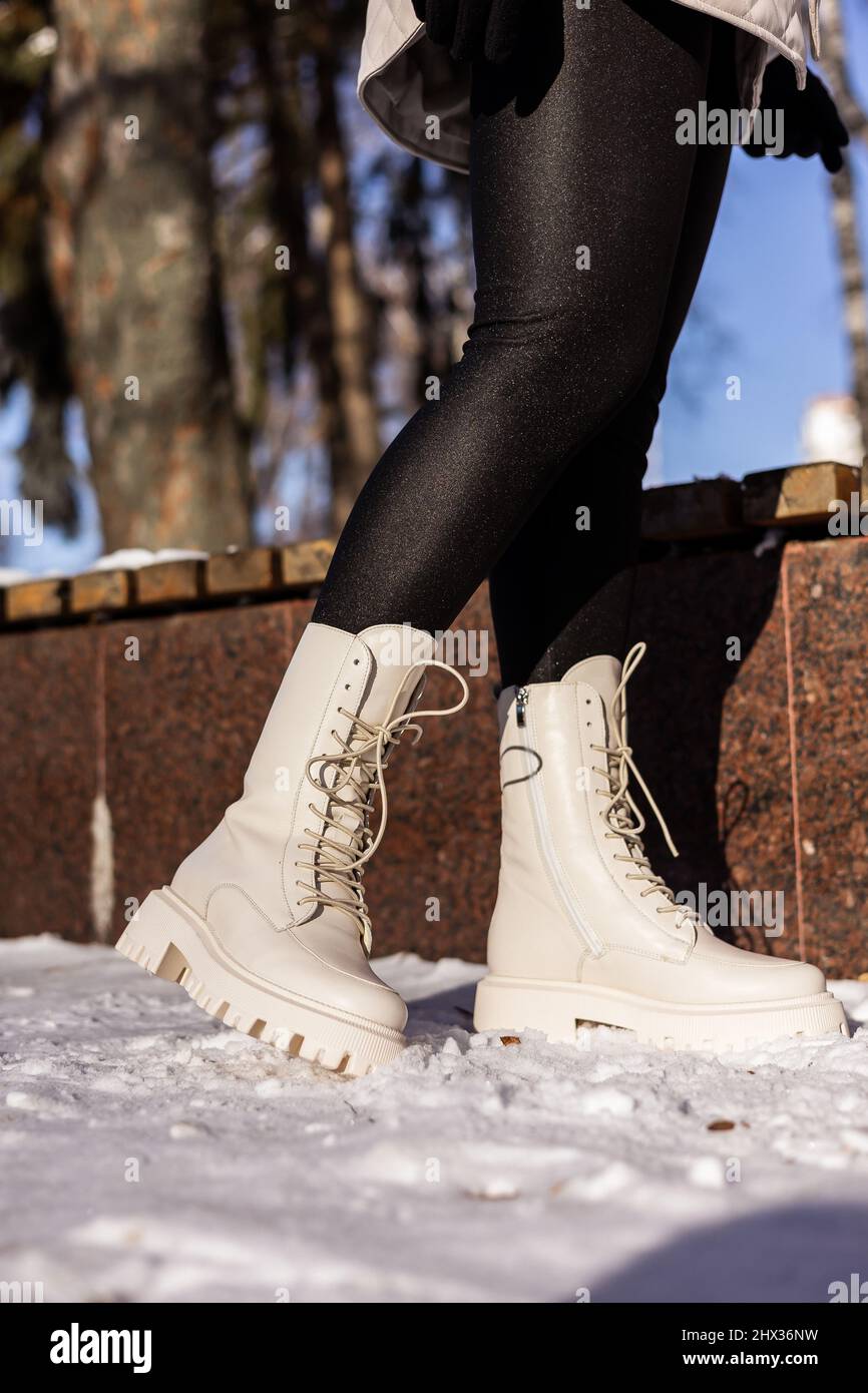 Mujer con botas blancas de sobre nieve blanca, primer plano. Piernas para mujer con botas de piel invierno Fotografía stock - Alamy