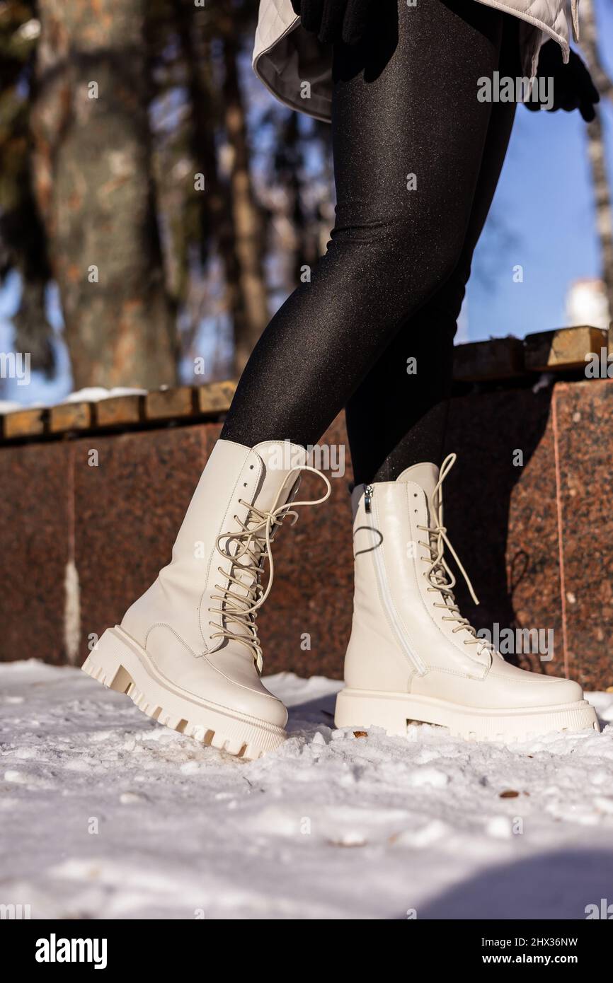 Mujer con botas blancas de moda sobre nieve blanca, primer plano. Piernas  para mujer con elegantes botas de piel de invierno Fotografía de stock -  Alamy