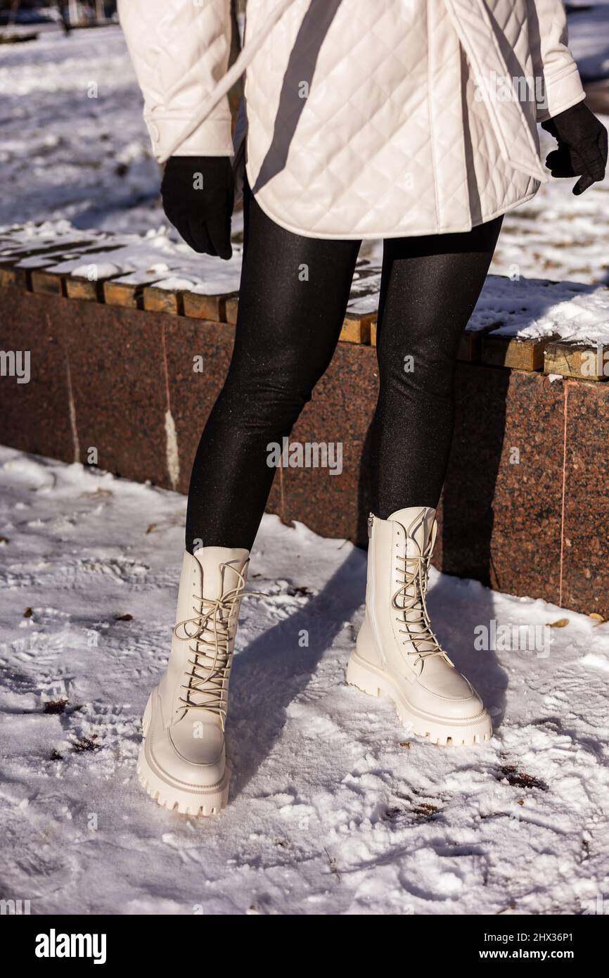 lento barrera col china Mujer con botas blancas de moda sobre nieve blanca, primer plano. Piernas  para mujer con elegantes botas de piel de invierno Fotografía de stock -  Alamy