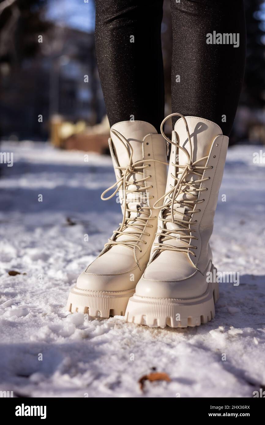 Mujer con botas blancas de moda sobre nieve blanca, primer plano. Piernas  para mujer con elegantes botas de piel de invierno Fotografía de stock -  Alamy