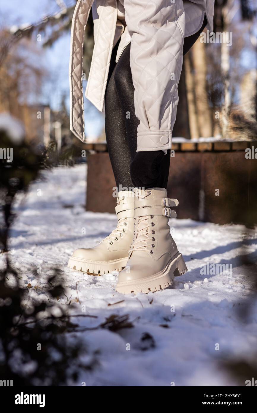 Mujer con botas blancas de moda sobre nieve primer plano. Piernas para mujer con elegantes botas de piel de invierno Fotografía de stock - Alamy