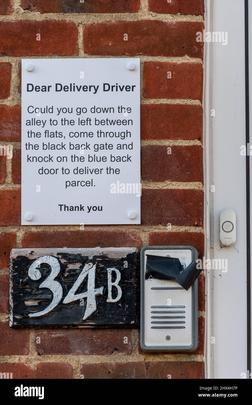 Instrucciones al lado de un timbre de la casa para un conductor de entrega diciéndole dónde dejar los paquetes con seguridad, Reino Unido Foto de stock