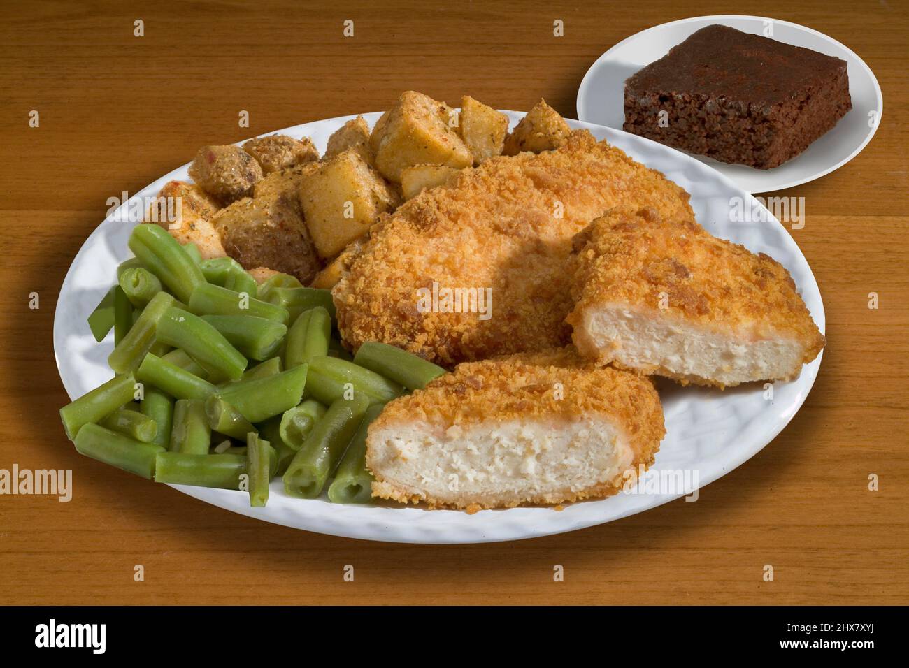 Hornee pollo crujiente con judías verdes y patatas asadas Foto de stock