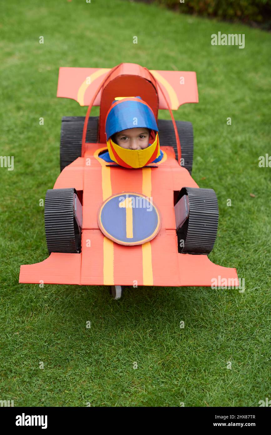 académico cerebro Oblea Niños con cardboard modelos de coches de carreras/disfraces, jugando en el  jardín Fotografía de stock - Alamy