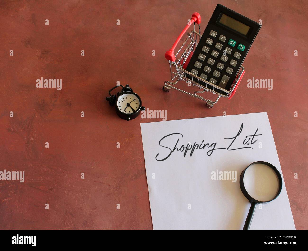 Calculadora, carro de la compra, lupa y papel con texto DE LA LISTA DE LA  COMPRA. Espacio de copia para texto Fotografía de stock - Alamy