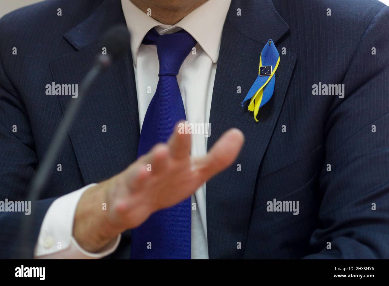 Ciolpani, Rumania - 10 de marzo de 2022: Detalles con un alto funcionario de la Comisión Europea que lleva un pin de la Comisión Europea y una cinta de la bandera de Ucrania - Foto de stock