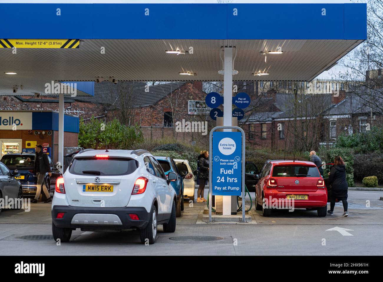 Wigan, Reino Unido: 10 de marzo de 2022: Poner en cola los coches esperando para comprar combustible en una estación de llenado de gasolina Tesco, ya que los conductores británicos pánico comprar combustible Foto de stock
