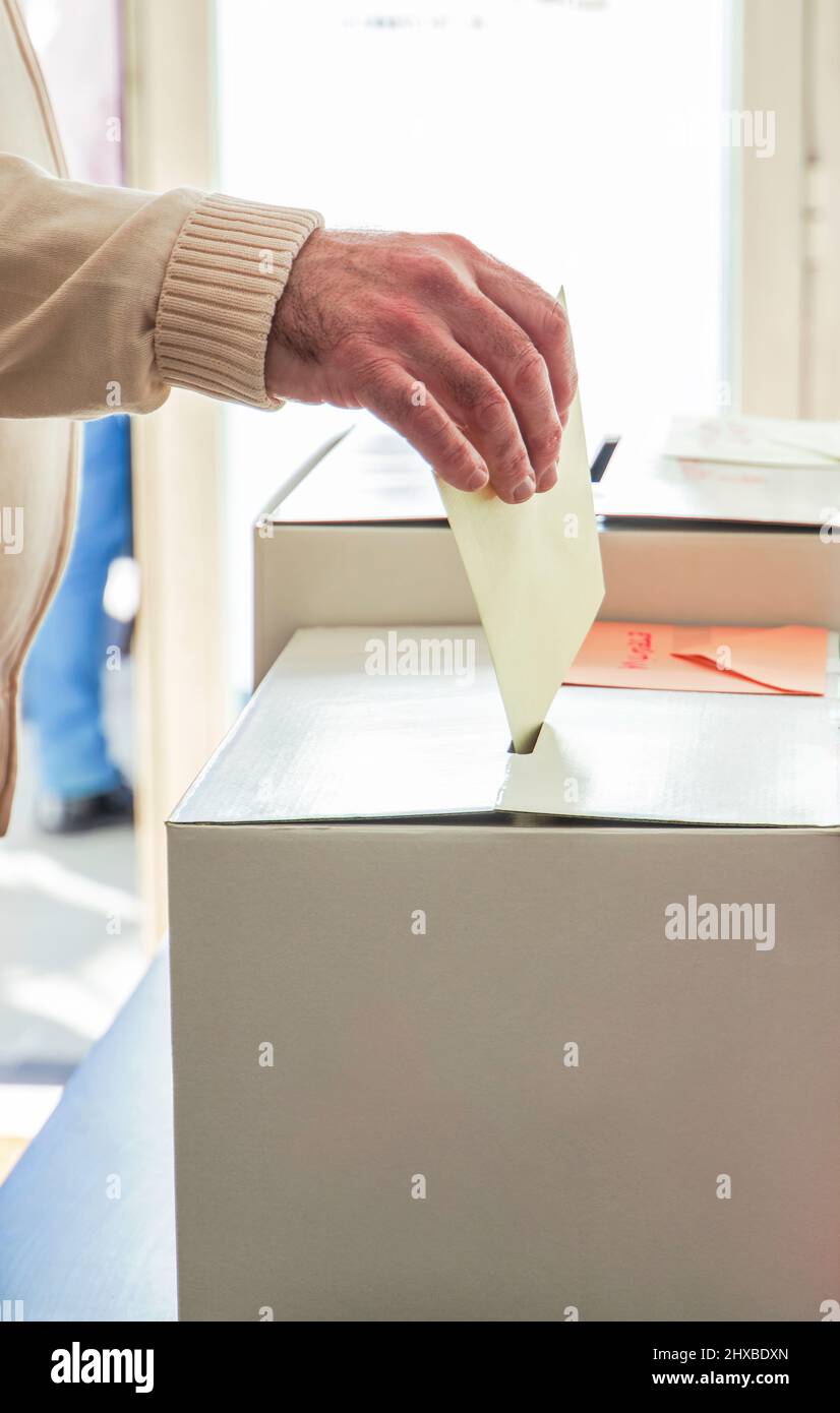 Una persona votando durante las elecciones. Votante Poniendo el voto en la urna. Concepto de elección. Primer plano Foto de stock