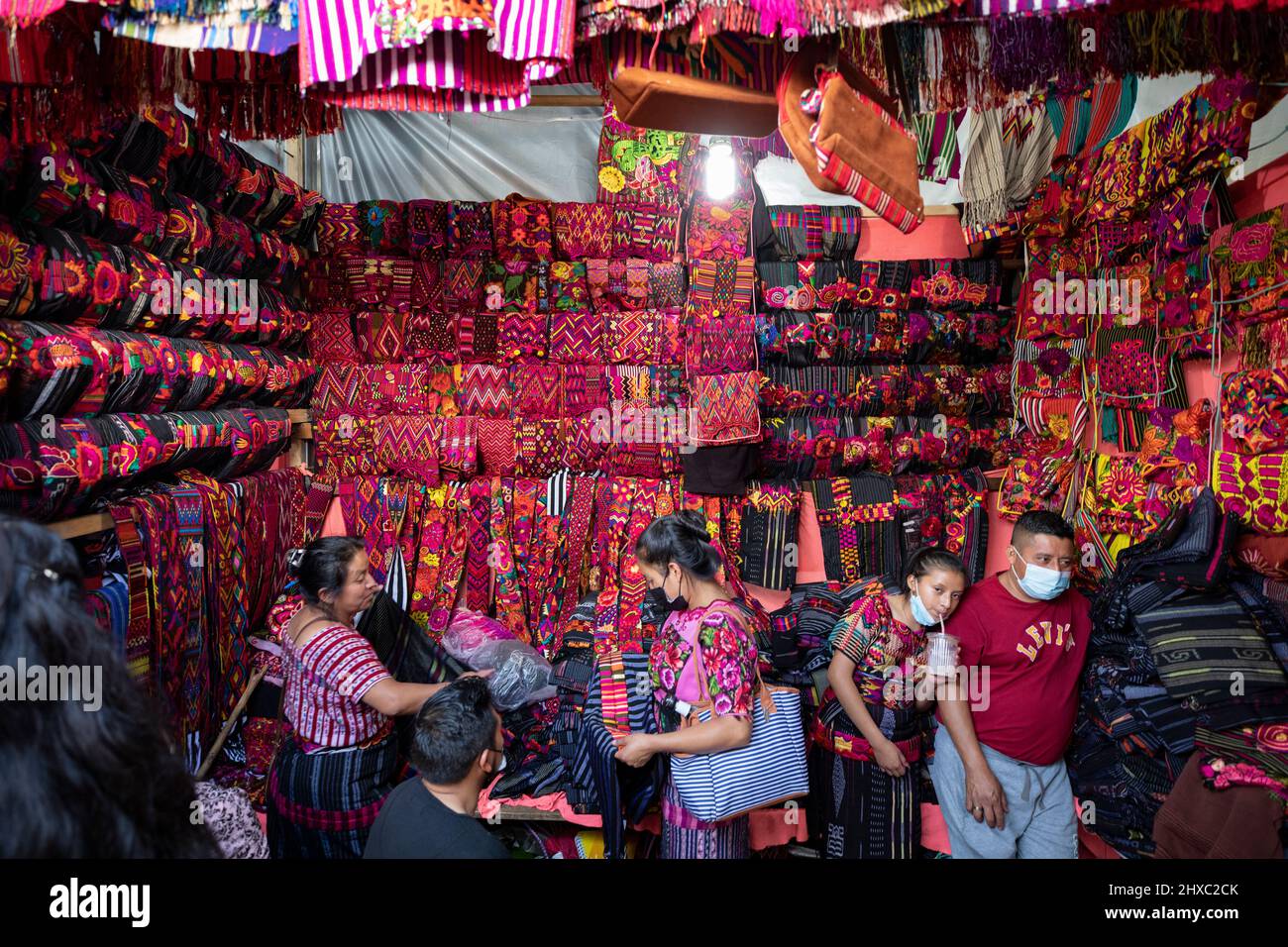 Los vestidos y telas están a la venta en el colorido mercado semanal de Chichicastenango en Guatemala, Centroamérica. Foto de stock