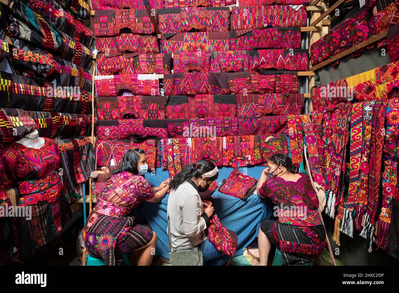 Los vestidos y telas están a la venta en el colorido mercado semanal de Chichicastenango en Guatemala, Centroamérica. Foto de stock