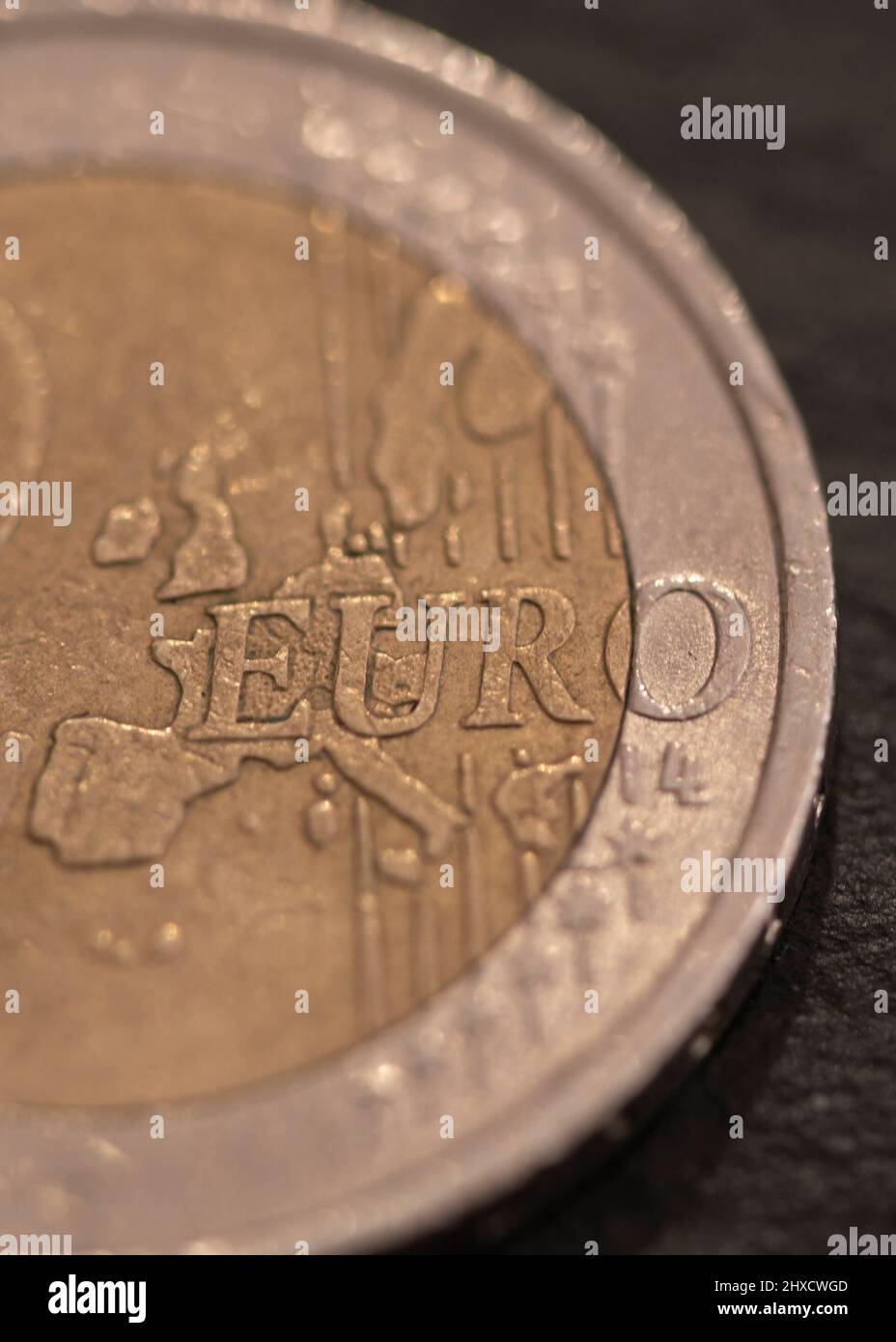Moneda de dos euros, se encuentra en pizarra negra. Foto de stock
