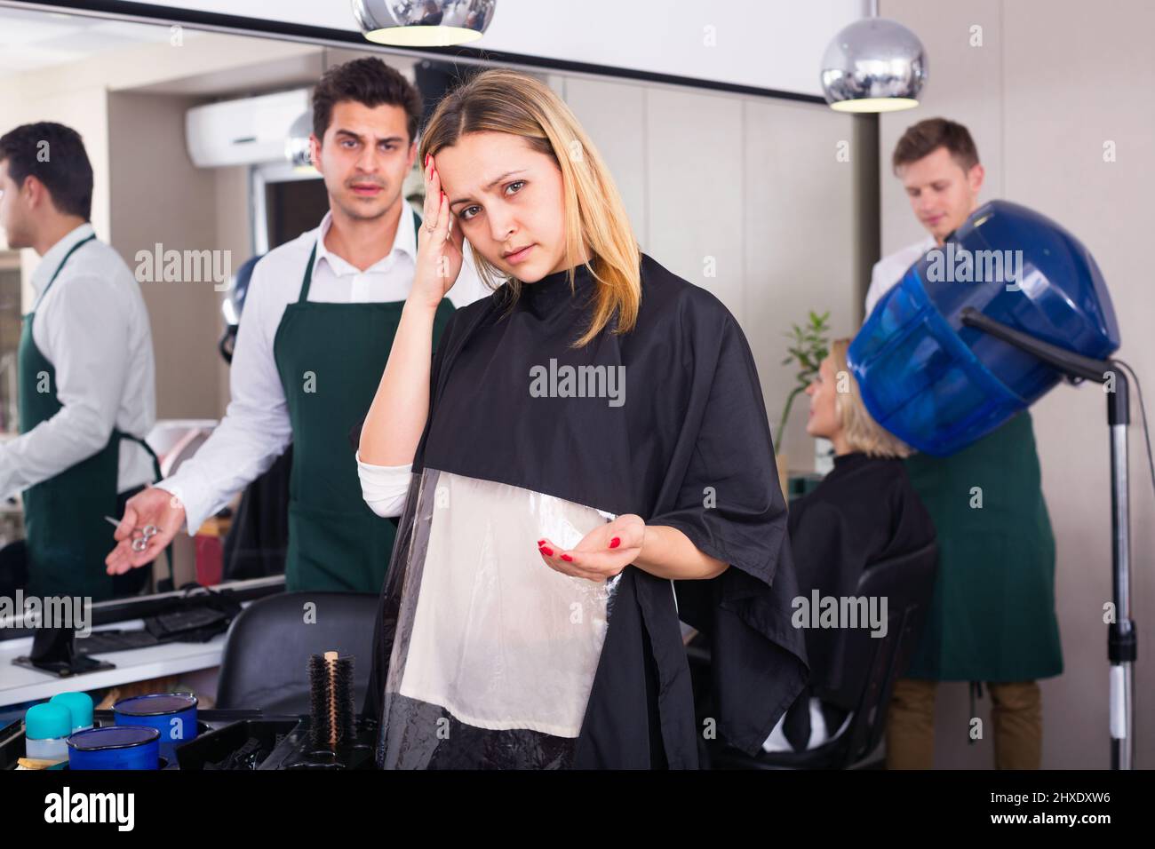 mujer que culpa a la peluquería en mal corte de pelo Foto de stock