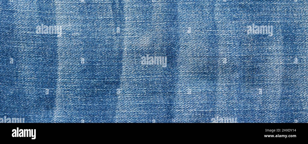 Foto detallada de tejido de jeans azules, denim clásico. Pantalones vaqueros de fondo, textura. Foto de stock