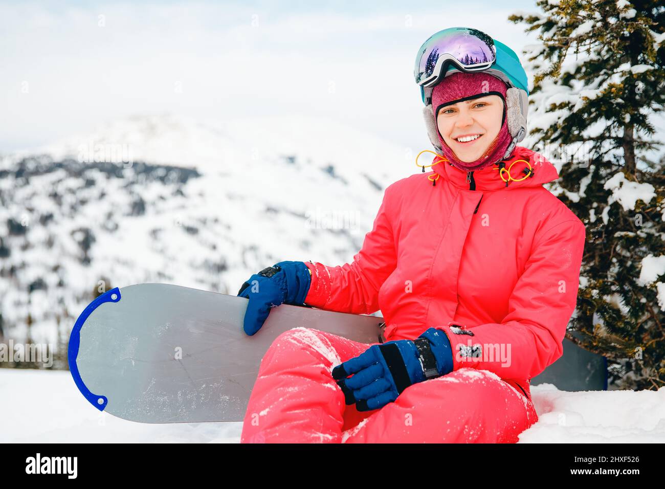 Mujer deportista con snowboard en ropa roja sentada en el bosque de nieve  fondo. Concepto de deporte de invierno, región de Sheregesh Kemerovo Rusia  Fotografía de stock - Alamy