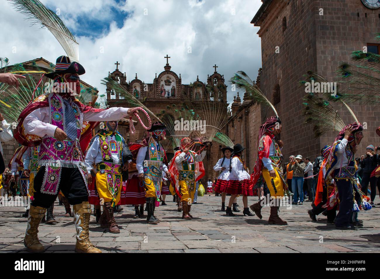 Cuzco, Perú - 25 de diciembre de 2013: Un grupo de personas que visten ropa y máscaras tradicionales durante la Huaylia el día de Navidad frente al gato del Cuzco Foto de stock
