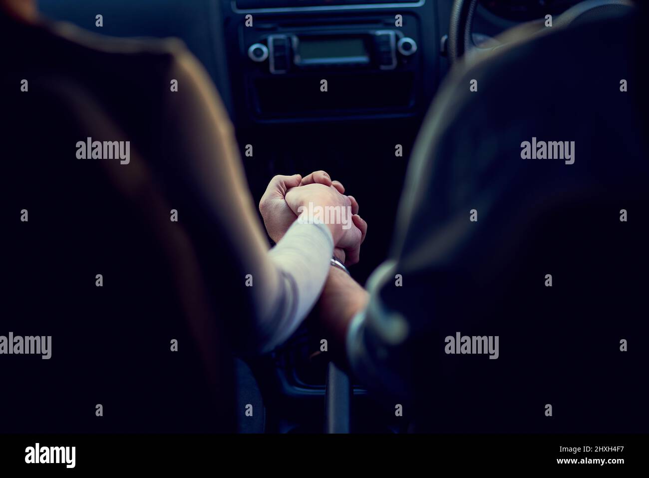 Alejarse de todo menos el uno del otro. Imagen de la parte trasera de una pareja irreconocible sujetando las manos mientras conducía en un coche. Foto de stock