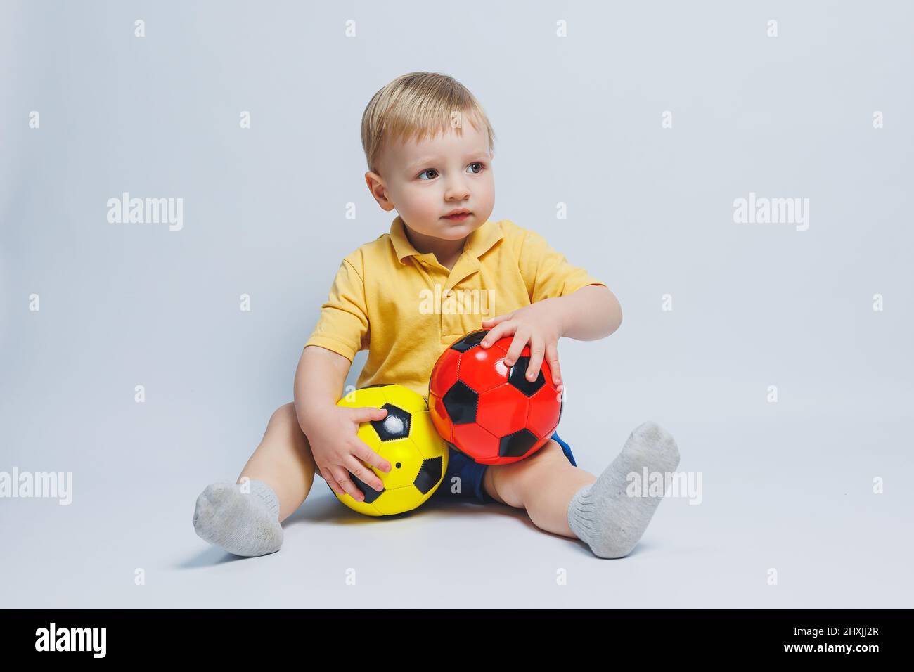 Niño pequeño con la pelota de fútbol sobre fondo amarillo Fotografía de  stock - Alamy