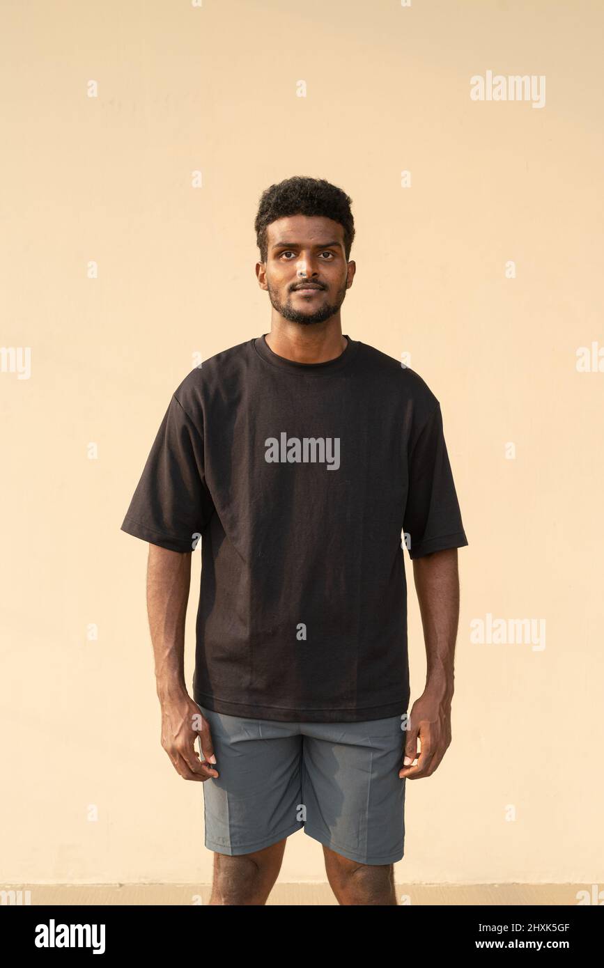 Retrato de un hermoso joven africano con una camiseta negra de gran tamaño Foto de stock