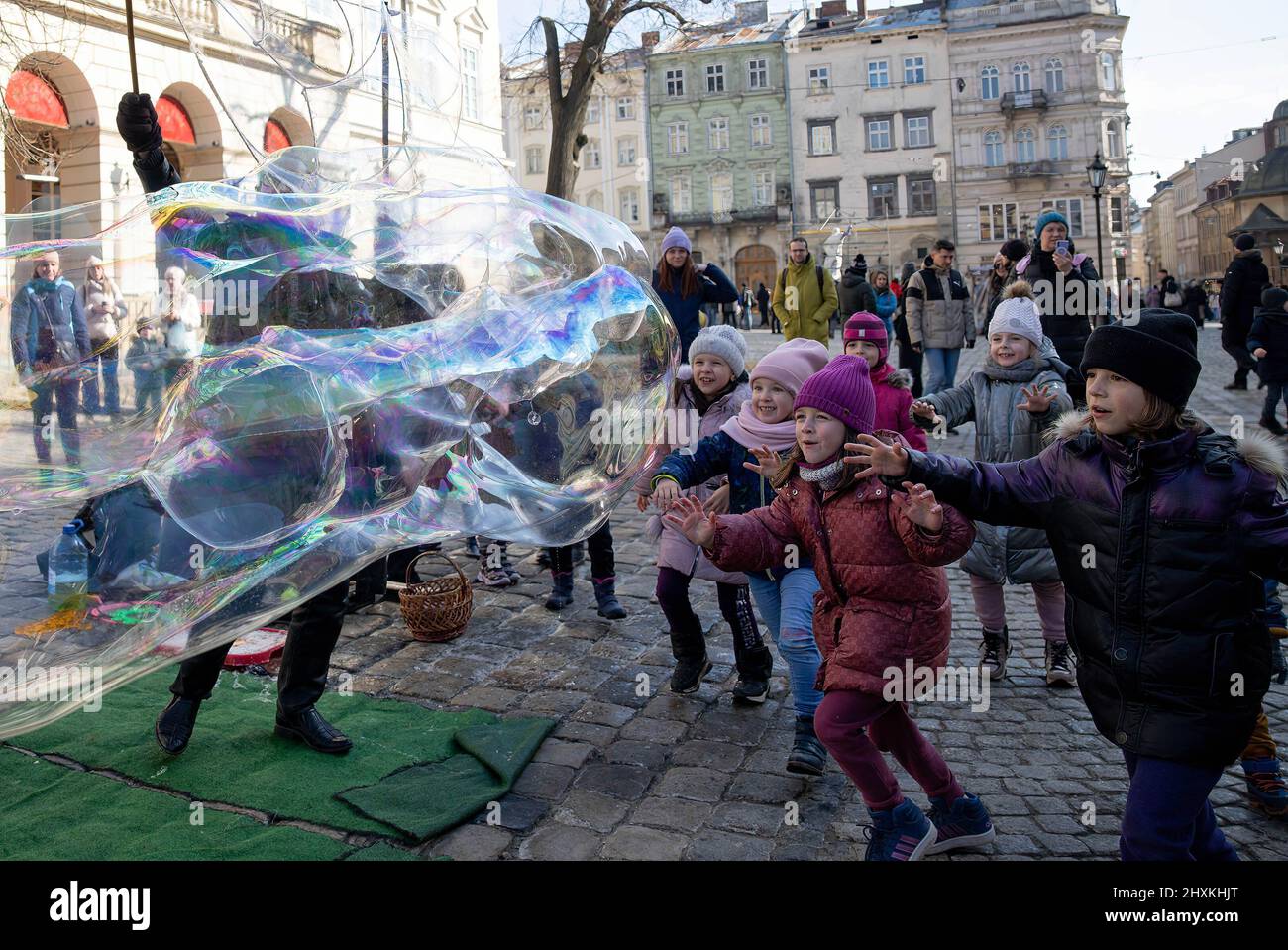13 de marzo de 2022, Lviv, Ucrania: Se ve a los niños jugando con burbujas de jabón en el centro de la ciudad de Lviv. Los civiles en Lviv tratan de vivir su vida diaria a pesar de este ataque con bomba ruso por la mañana contra una base militar en las afueras de Lviv. (Imagen de crédito: © Hesther ng/SOPA Images via ZUMA Press Wire) Foto de stock